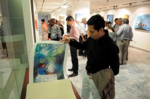 Asistente a la mestra revisando el Albun de las oras de diferntes artistas